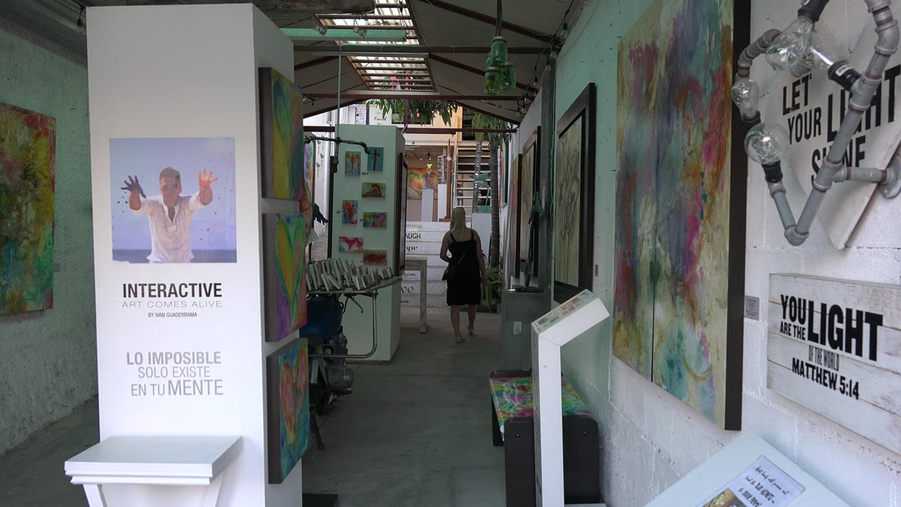 Colorful hallway with wall art and a person walking away in the distance.