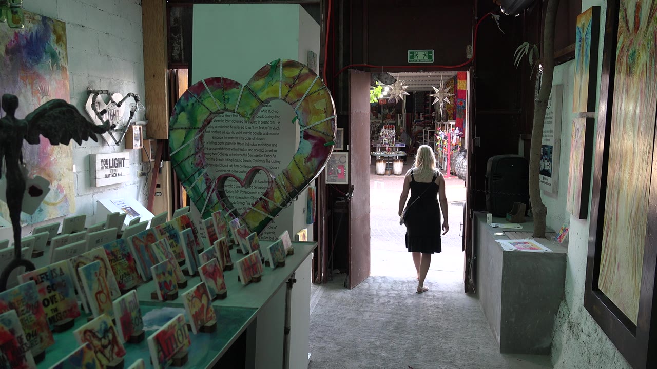 Dim shop interior with greeting cards and a woman near the open doorway