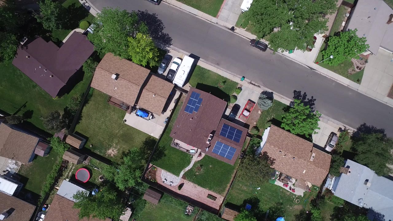 Overhead Westminster, Colorado frame showing a quiet street across the top, fenced yards, an RV in a driveway, solar panels on two roofs, and no visible people.