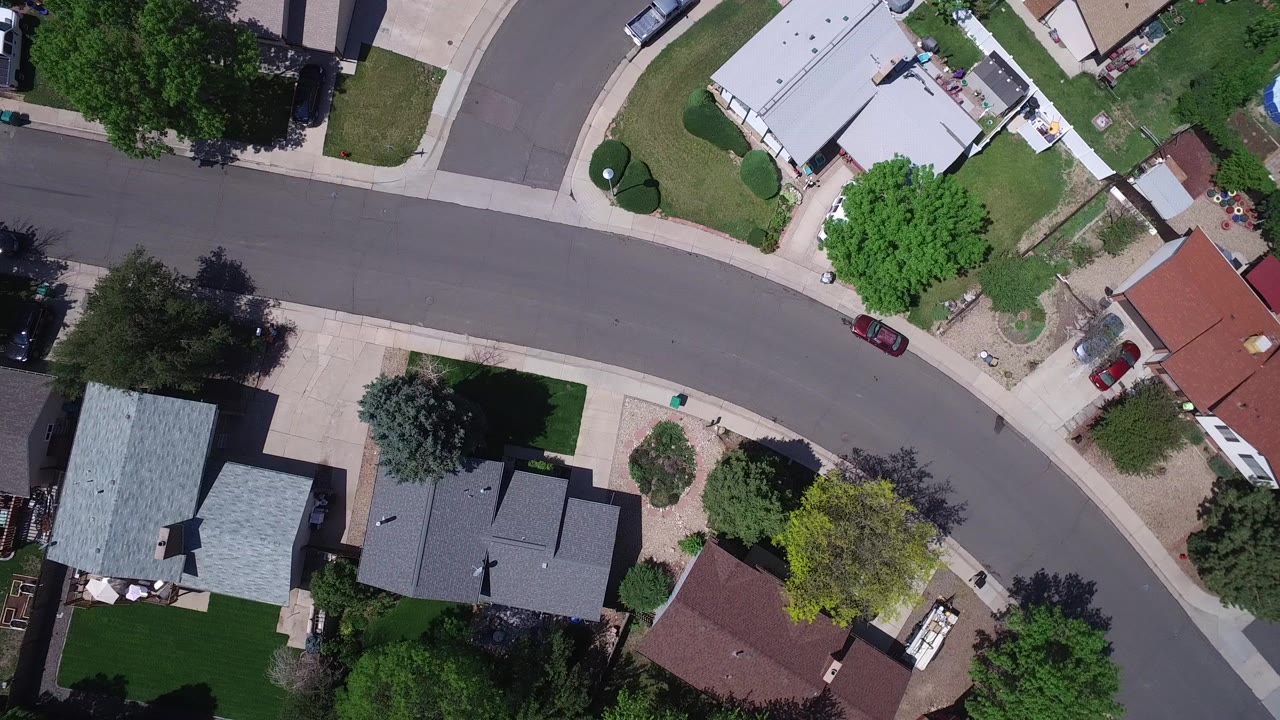 Overhead view of a curved suburban street and houses.