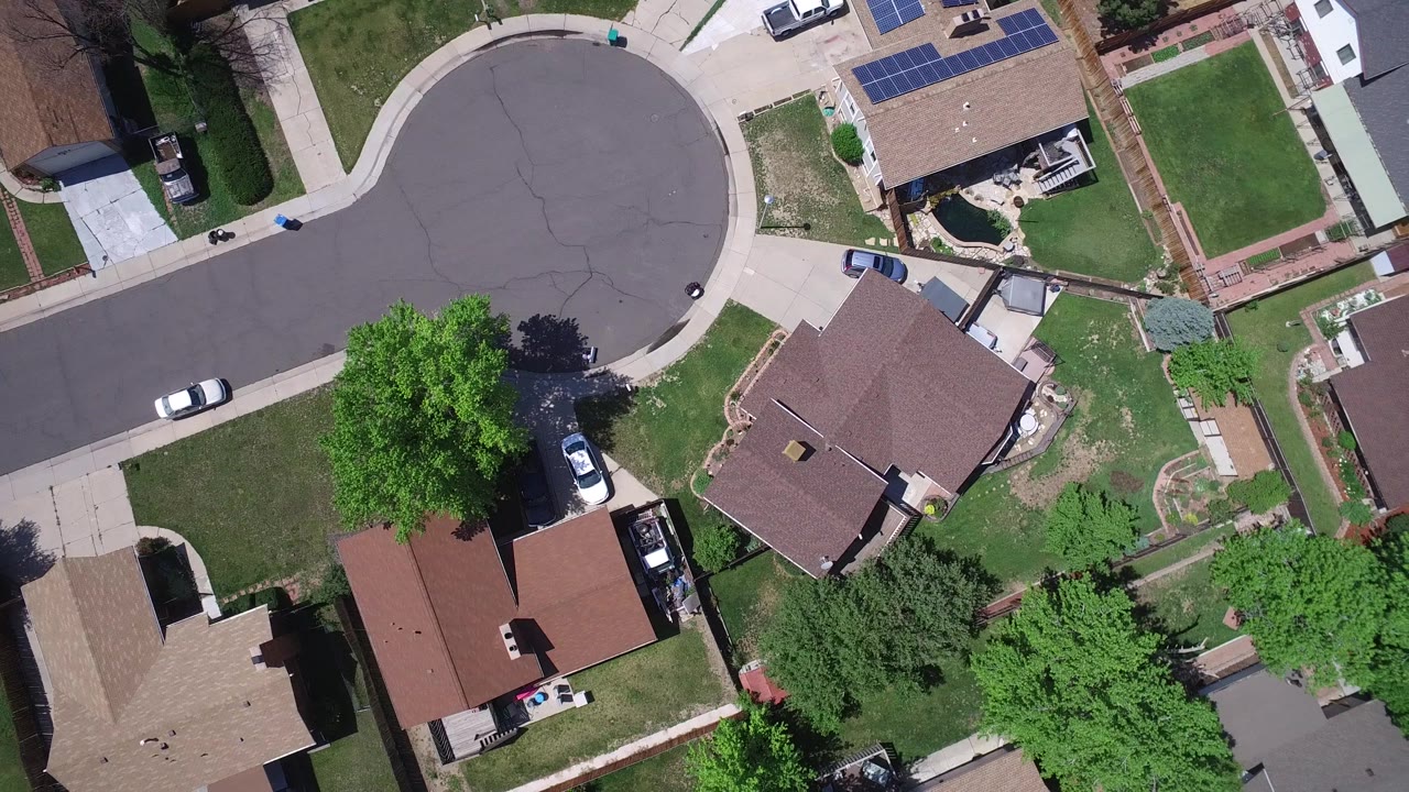 Aerial view in Westminster, Colorado showing the cul-de-sac shifted left, rooflines, fenced yards, a white car on the street, and no visible people.