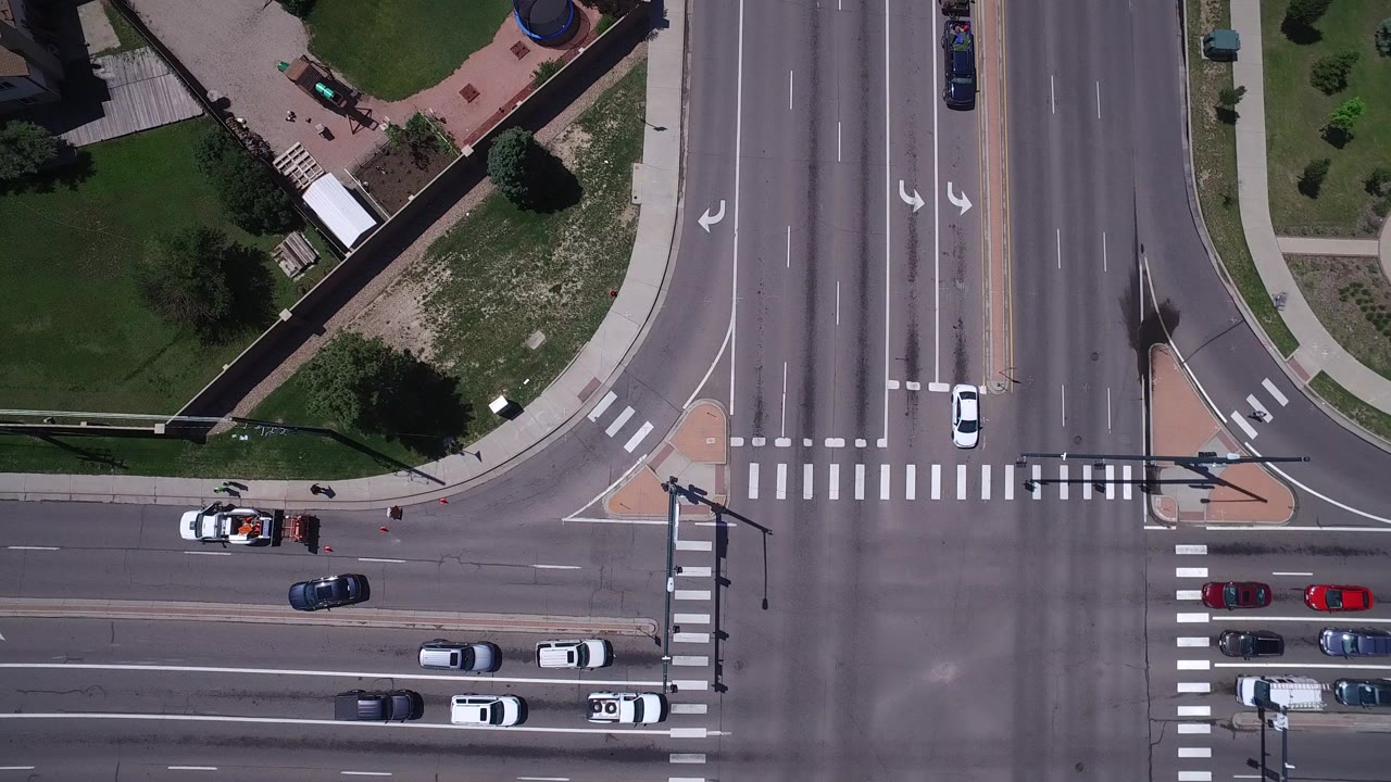 Overhead view of cars queued at a large four-way intersection.