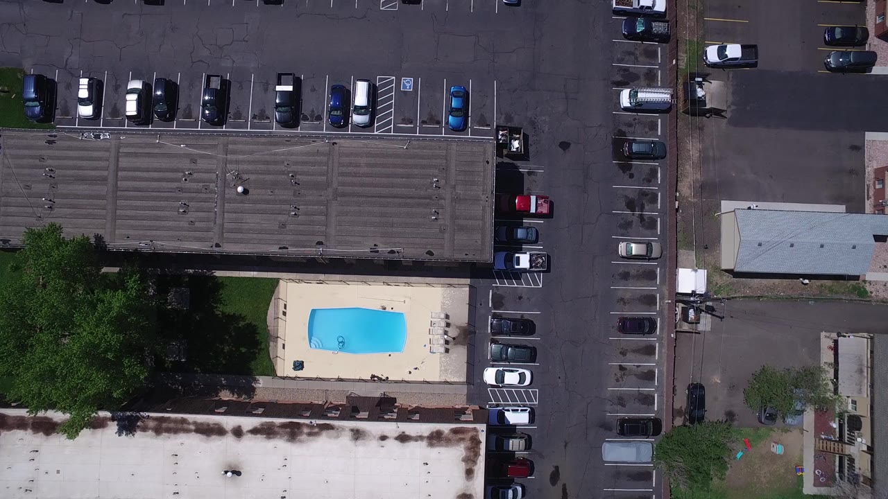 Overhead parking lot, buildings, trees, and small outdoor pool.