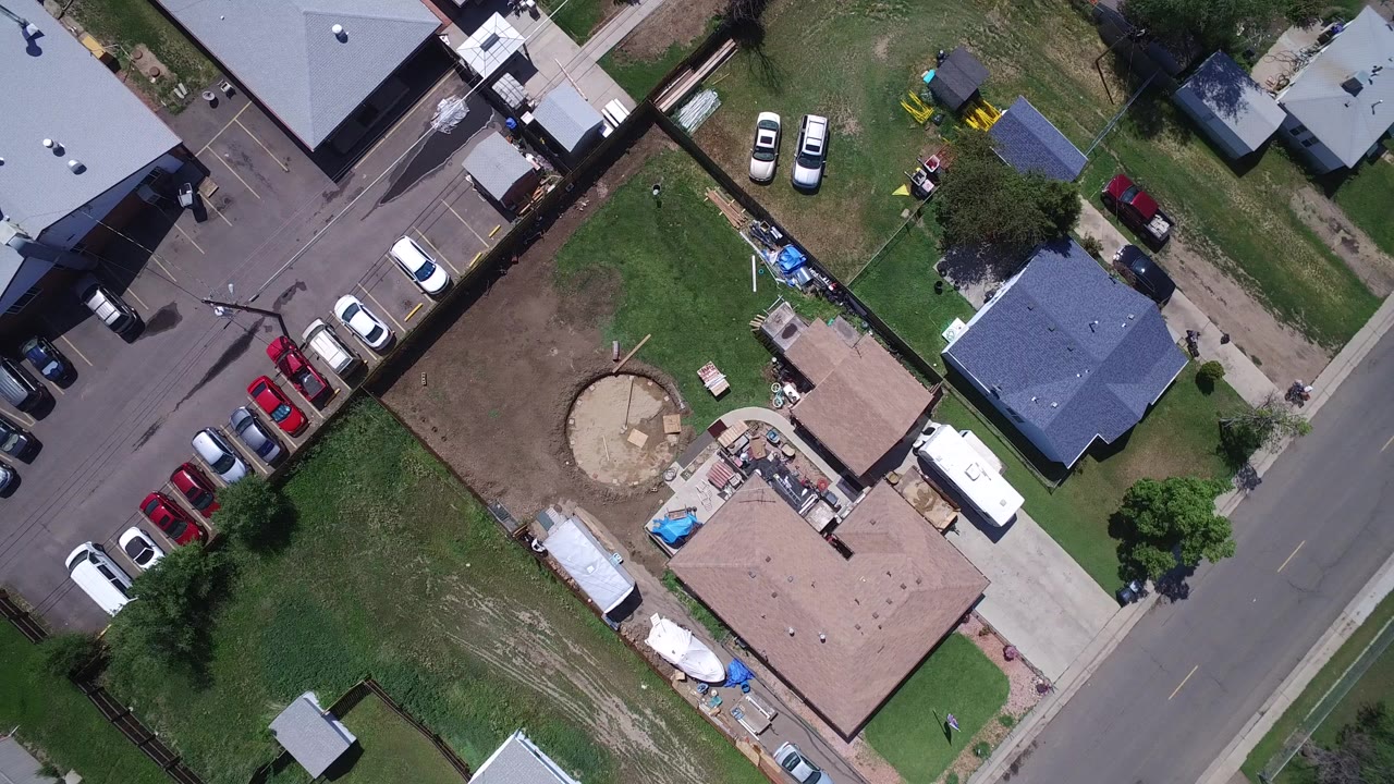 Overhead view of a residential road beside houses and parked cars.