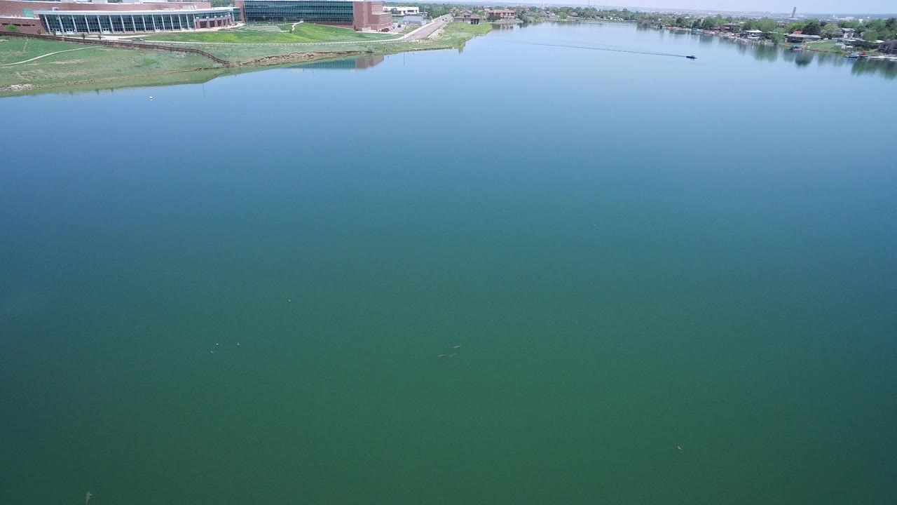Wide aerial view of a blue lake with shoreline buildings
