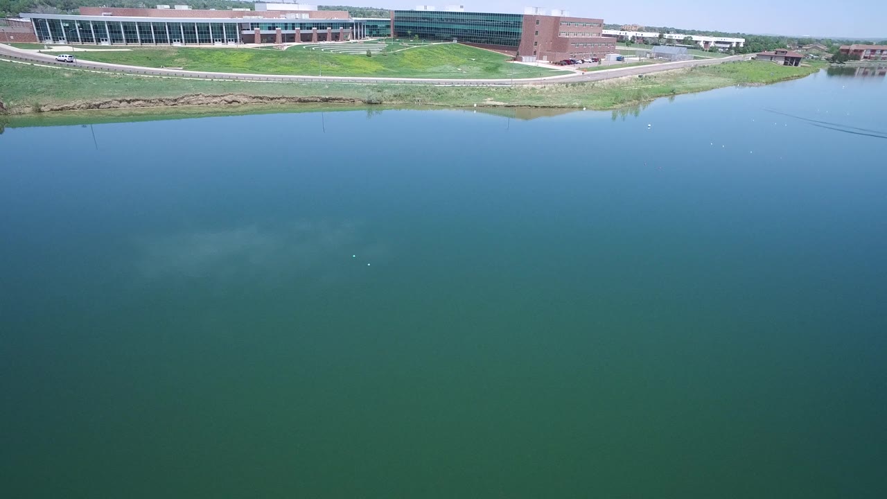 Blue water foreground with large shoreline building near the top of frame