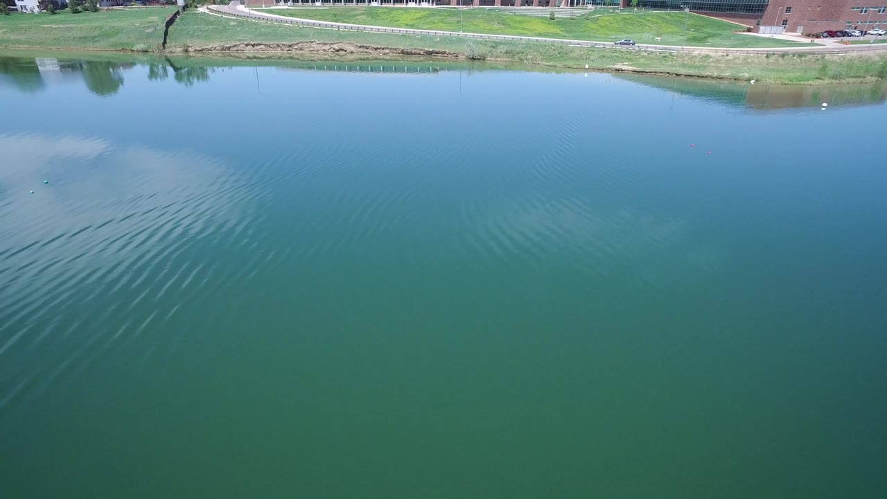 Lake surface with ripple lines and road along the far shore