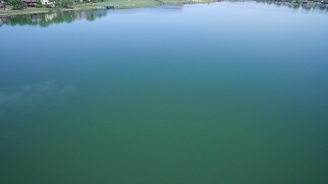 Blue-green lake water with a thin shoreline at the top edge.