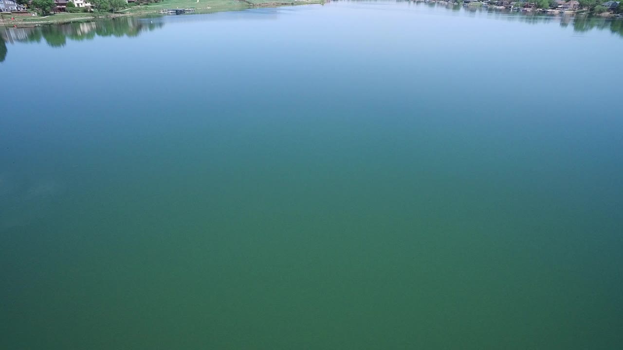 Wide green lake with distant shoreline at the top edge.