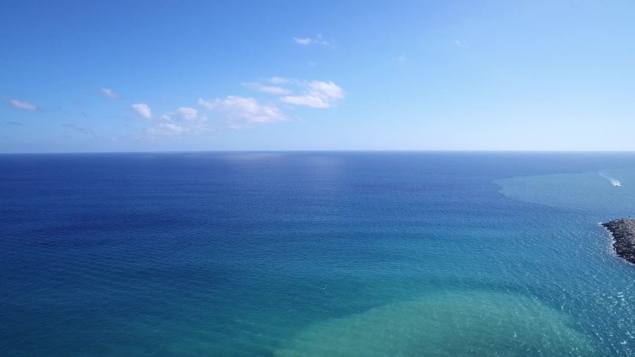 Second frame shows the Playita ocean horizon with a pale turquoise band on the right, darker blue water across the center, scattered small clouds, and no visible people.