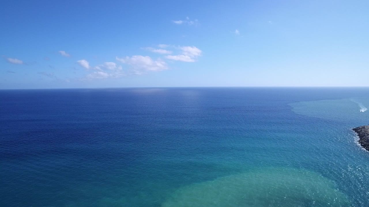 Blue ocean and turquoise shallows under a clear sky
