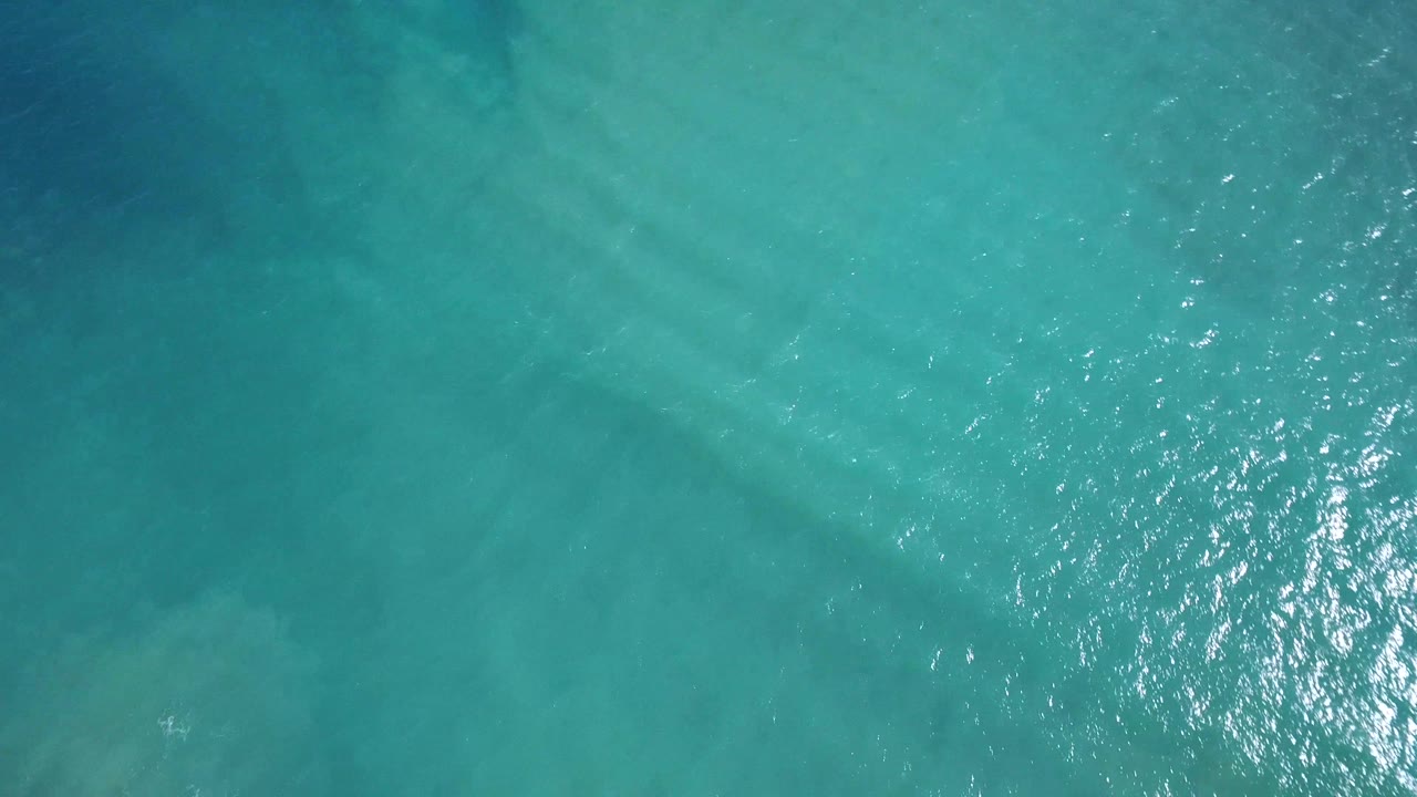 Turquoise water with a cluster of bright reflected light.
