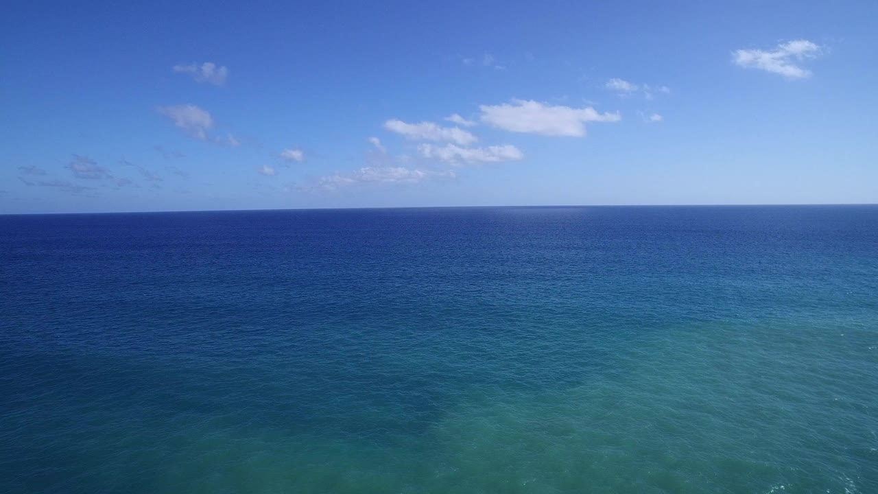 Blue ocean and sky with a straight horizon.
