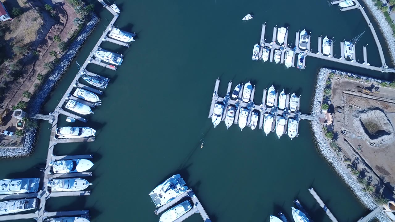 Overhead marina with docked white boats and green water