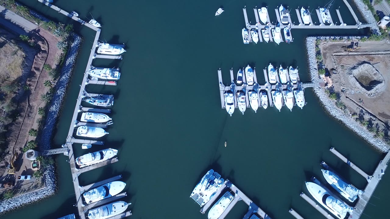Top-down marina basin with moored boats and open water center.