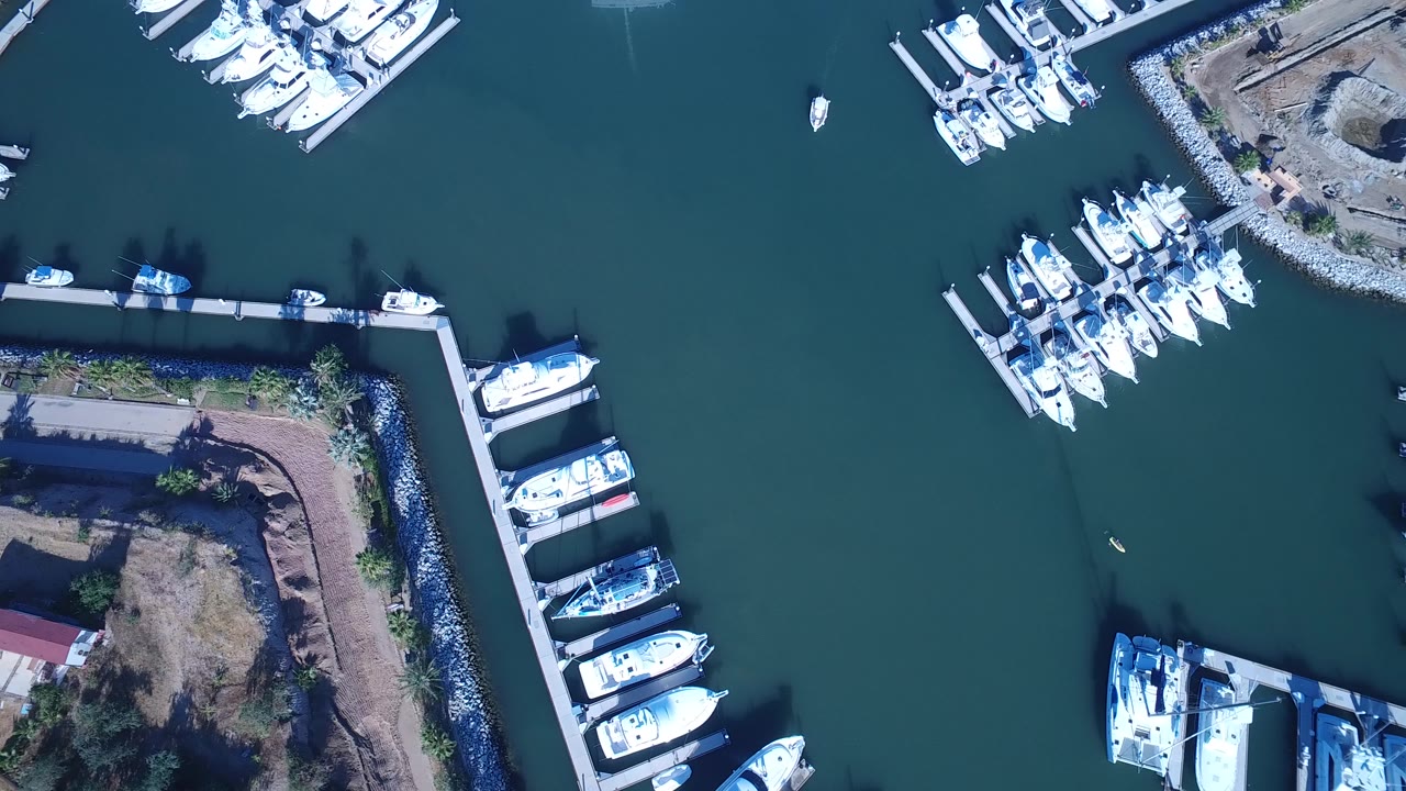 Overhead marina docks with white boats and green-blue water.