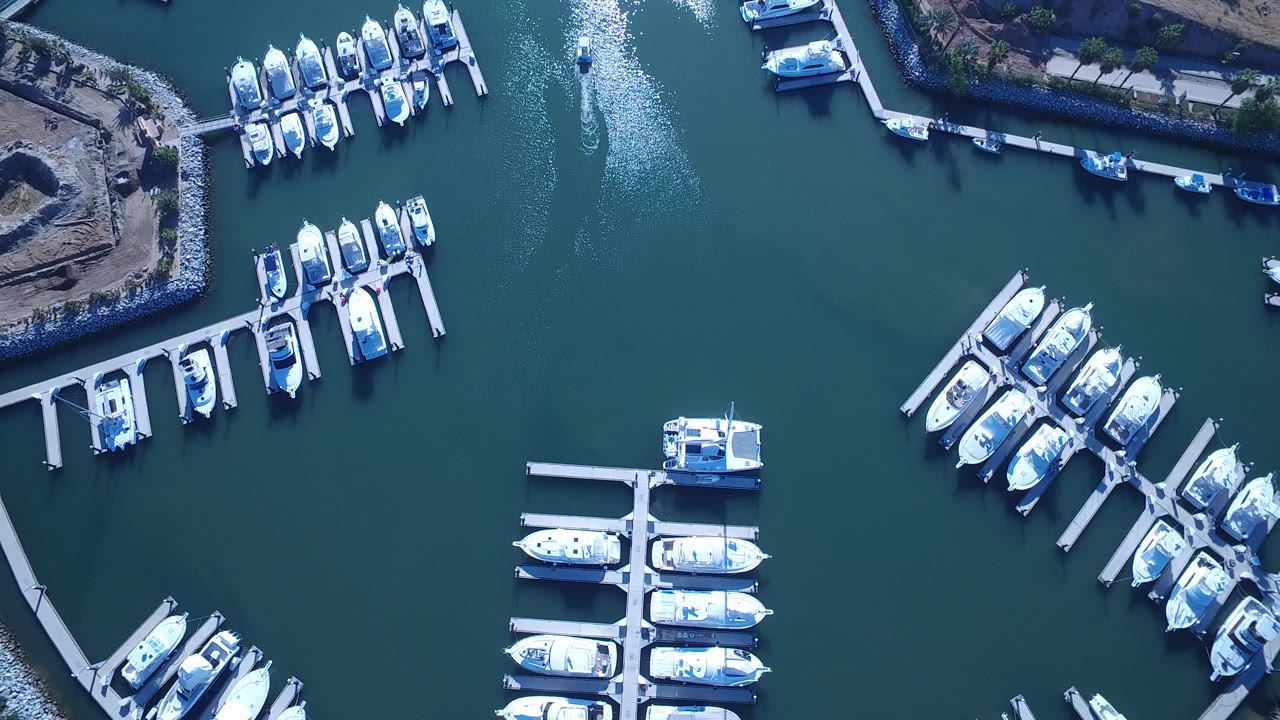 Top-down marina basin with moored boats and open water.