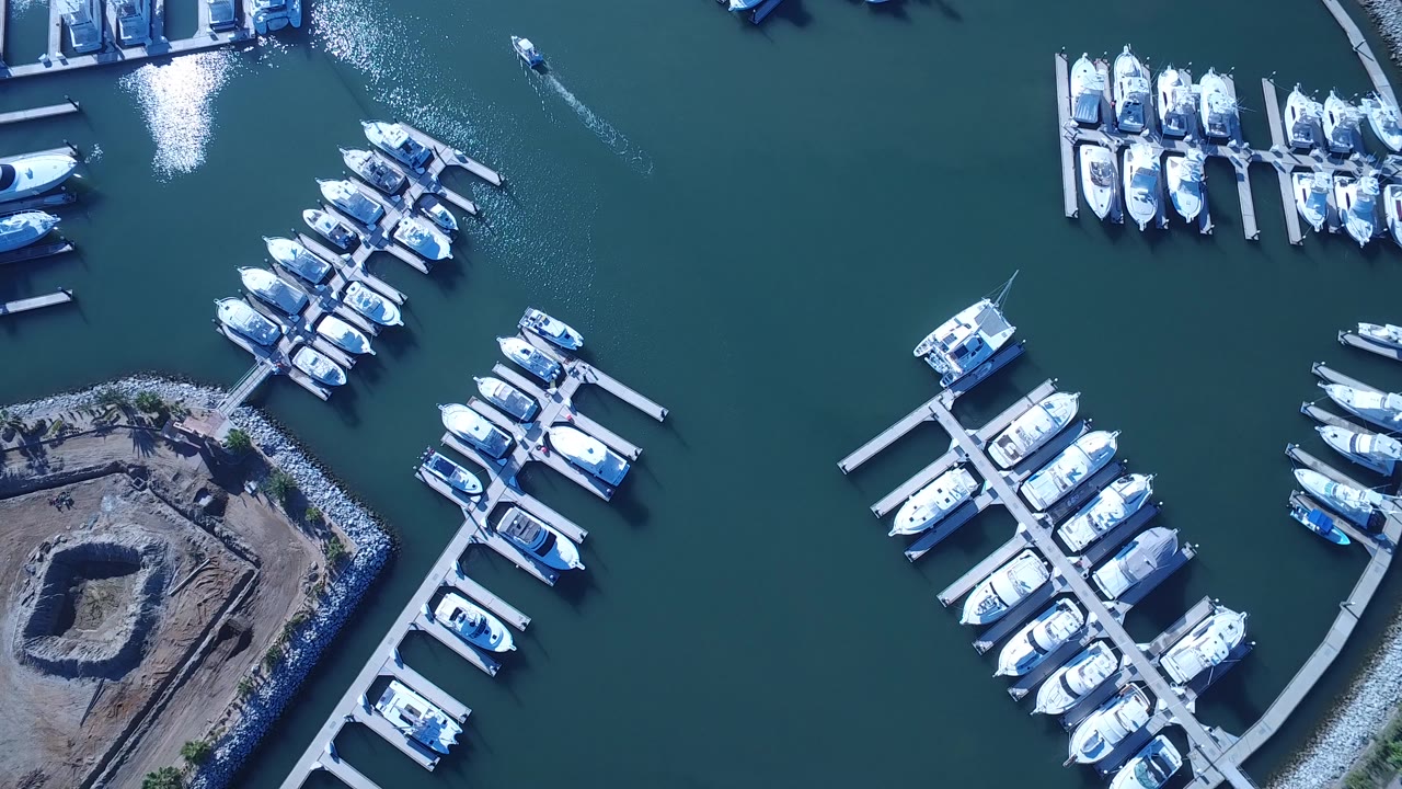 Overhead marina with docked white boats and rock shoreline