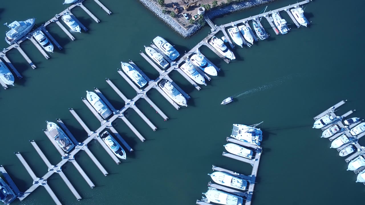 Overhead marina docks with white boats and dark teal water.