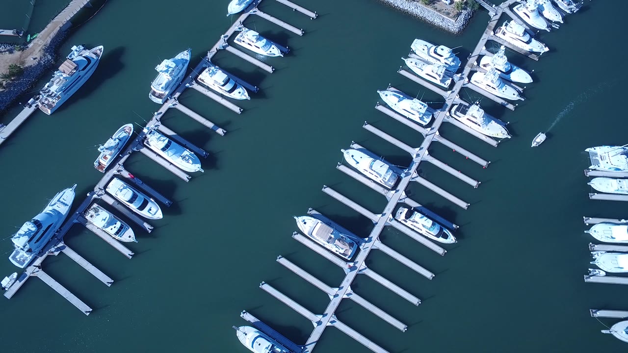 Top-down marina with boats and empty dock spaces