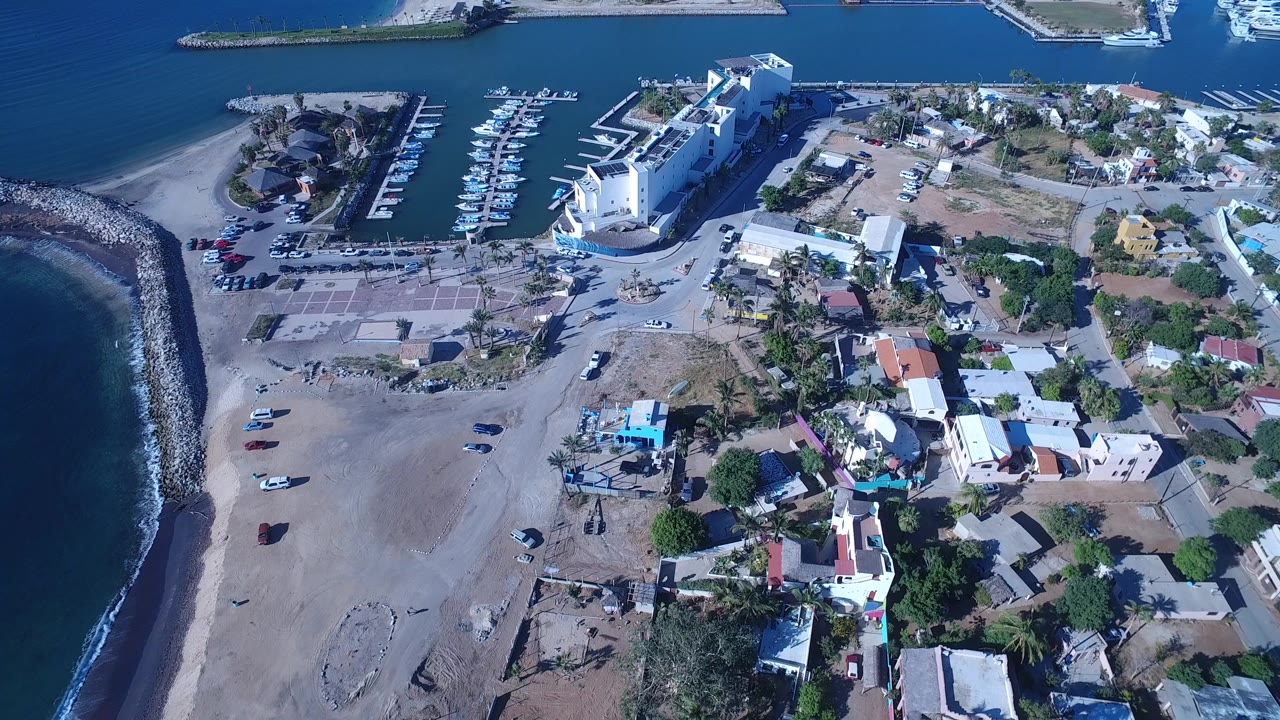 Aerial view of beach, breakwater, marina, and coastal homes