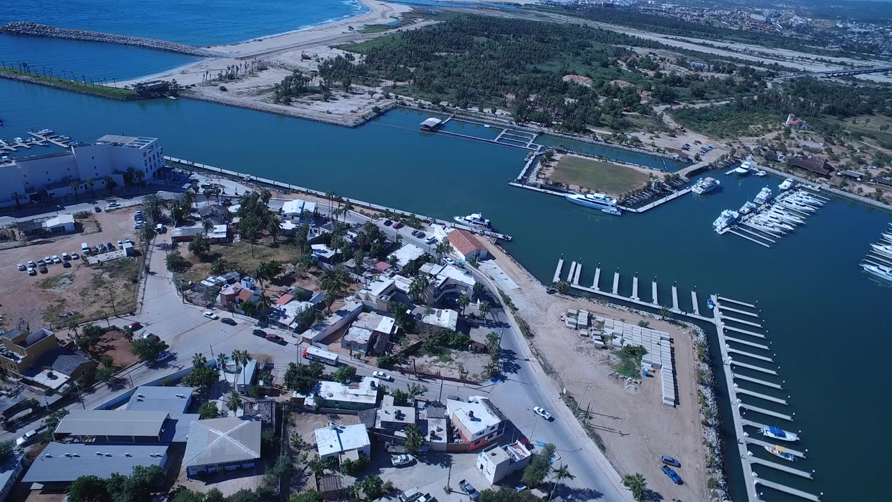 Aerial view of marina, canal, beach, and ocean.