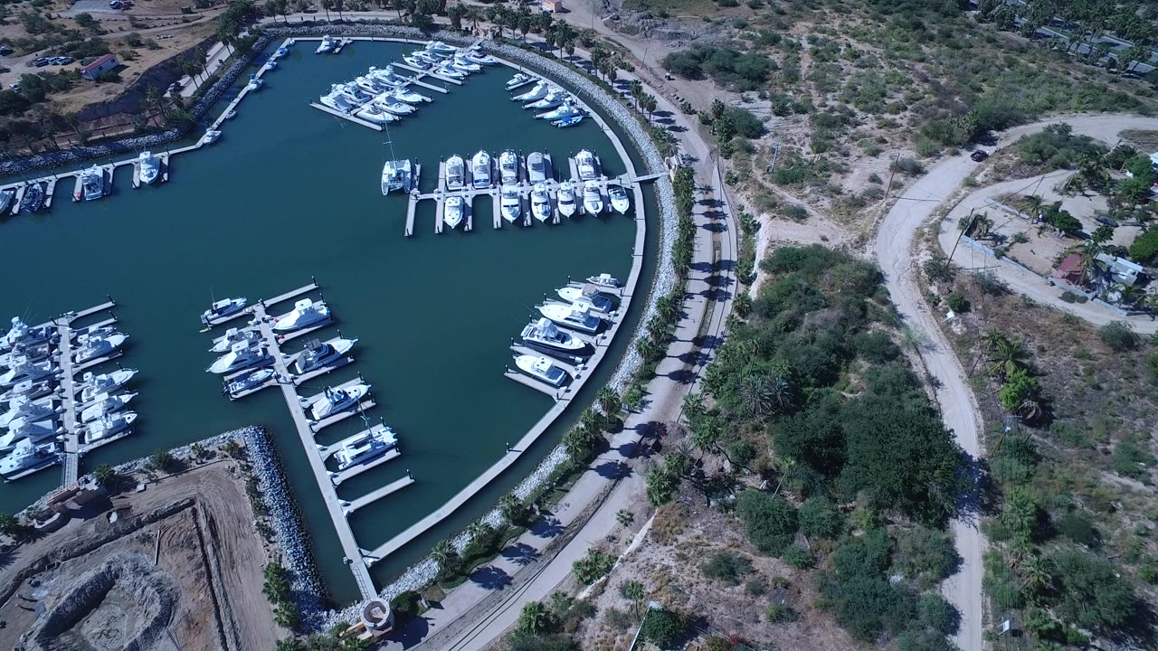 Aerial view of boats docked inside a curved marina basin.