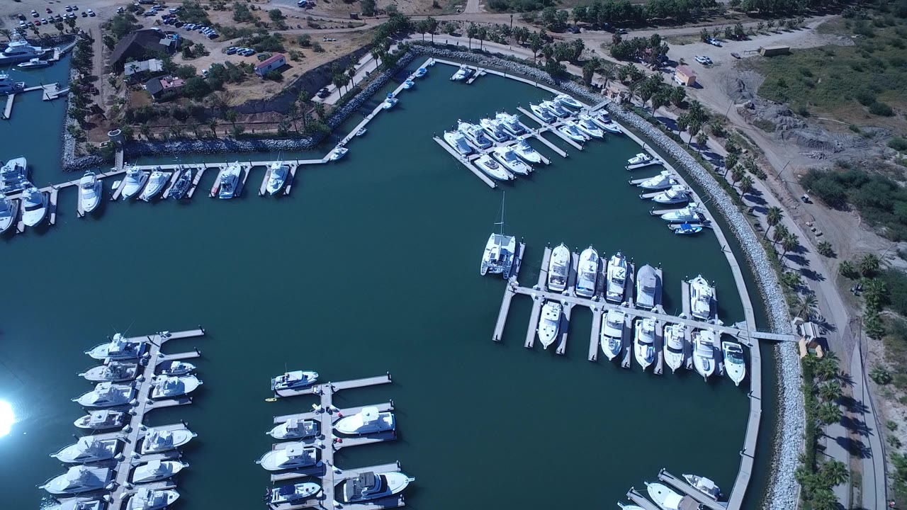 Drone view of marina docks with bright sun reflection on water