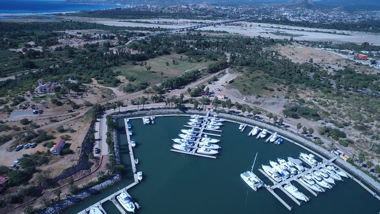 Aerial view of a marina with white boats and dry land beyond.