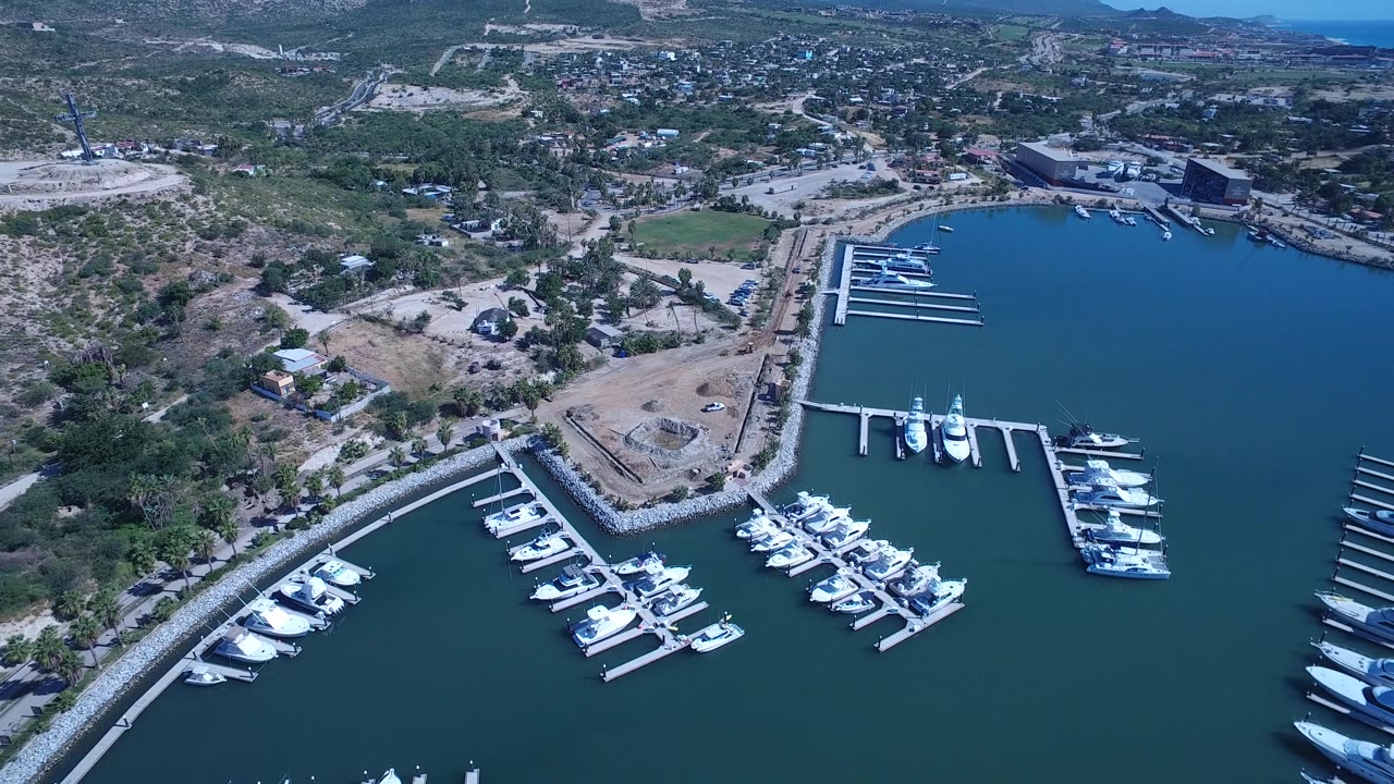 Aerial marina view with docks, yachts, shore lots, and town beyond.