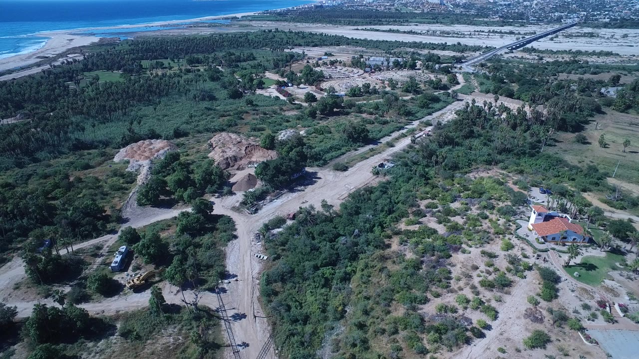 Aerial view of dunes, scrub, dirt roads, and ocean shoreline.