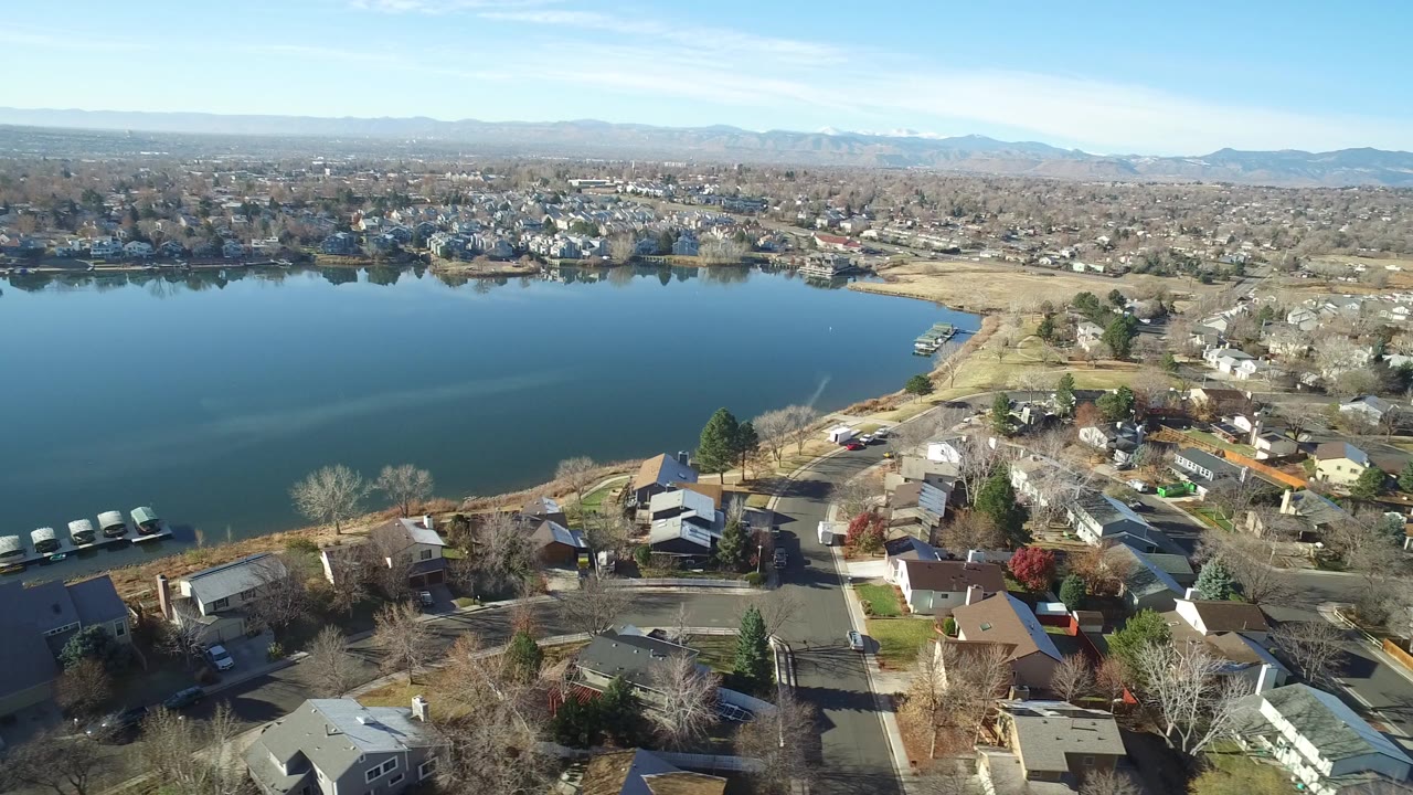 Aerial view of a lake beside residential streets and houses.