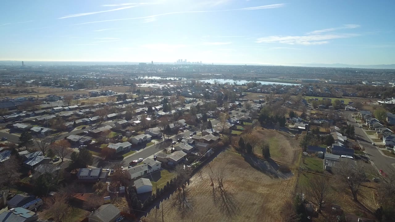 Aerial view over suburban houses and open grassland.