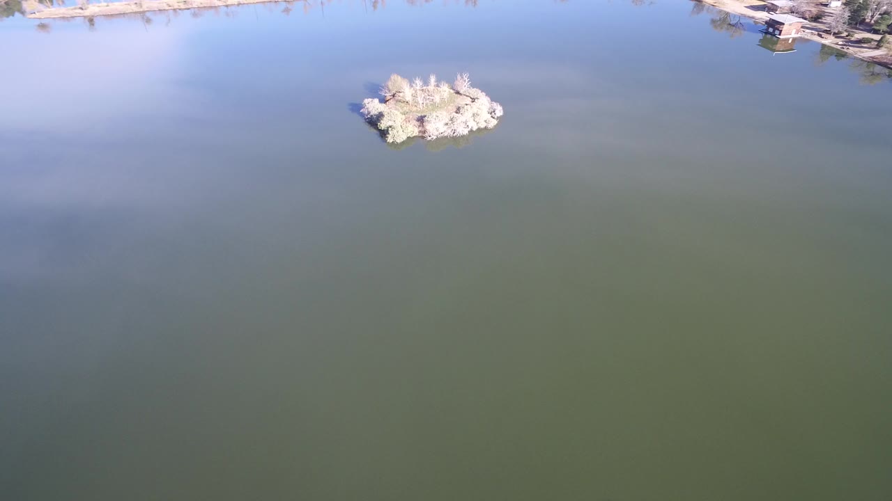 Overhead water view with a small pale island near the top edge.