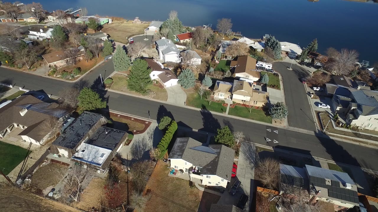 Aerial view of homes, streets, trees, and water.