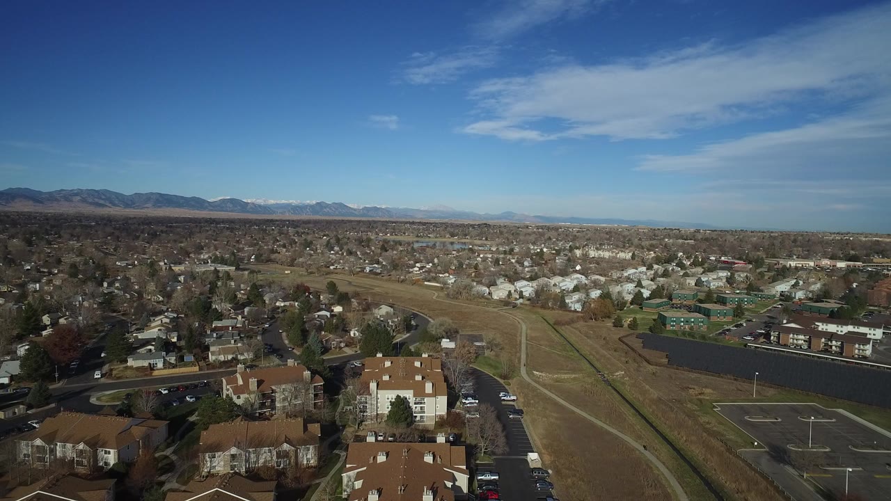 Aerial view of open field beside residential streets and houses.