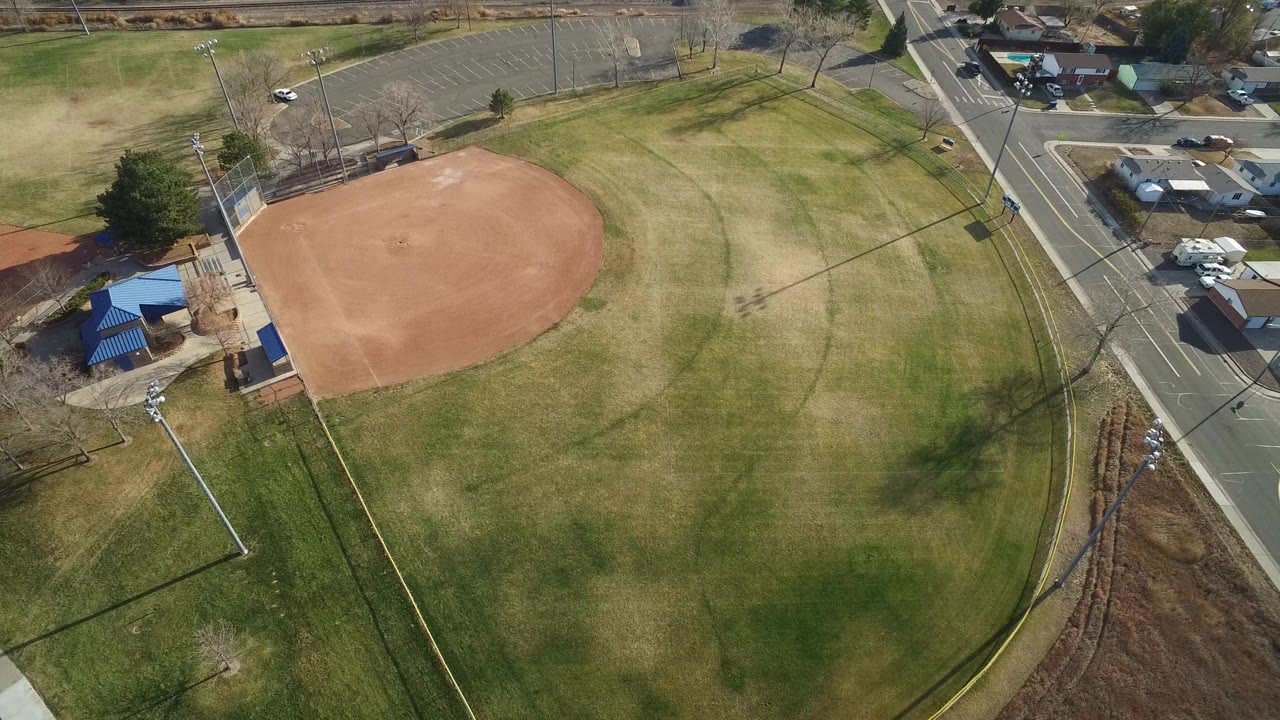 A slightly later aerial frame of the Westminster ballfield shows the empty infield shifted left in the composition, open grass across the center, and no visible people.