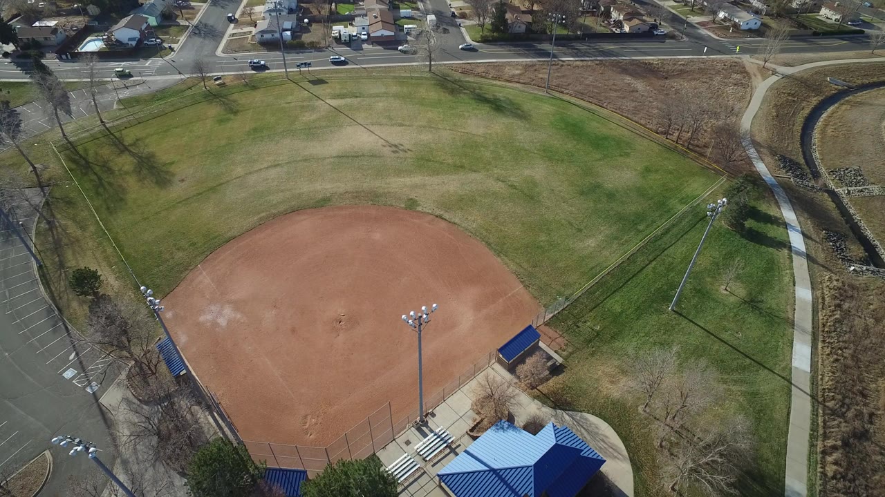 Aerial view of an empty baseball field beside roads and homes.