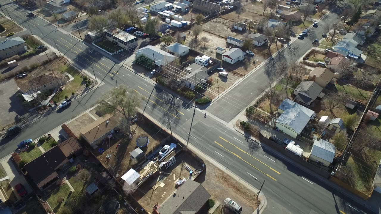 Aerial view of a suburban T-junction with houses and yards.