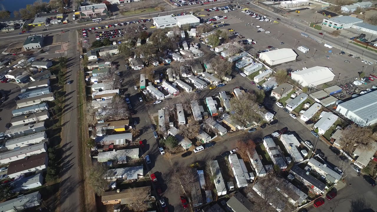 Overhead Westminster, Colorado frame with mobile home rows in the center, a straight tree-lined road at left, commercial buildings at top, and no visible people.