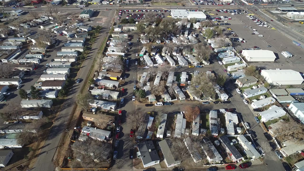 Aerial frame of trailers, cars, open lots, and nearby roadways.