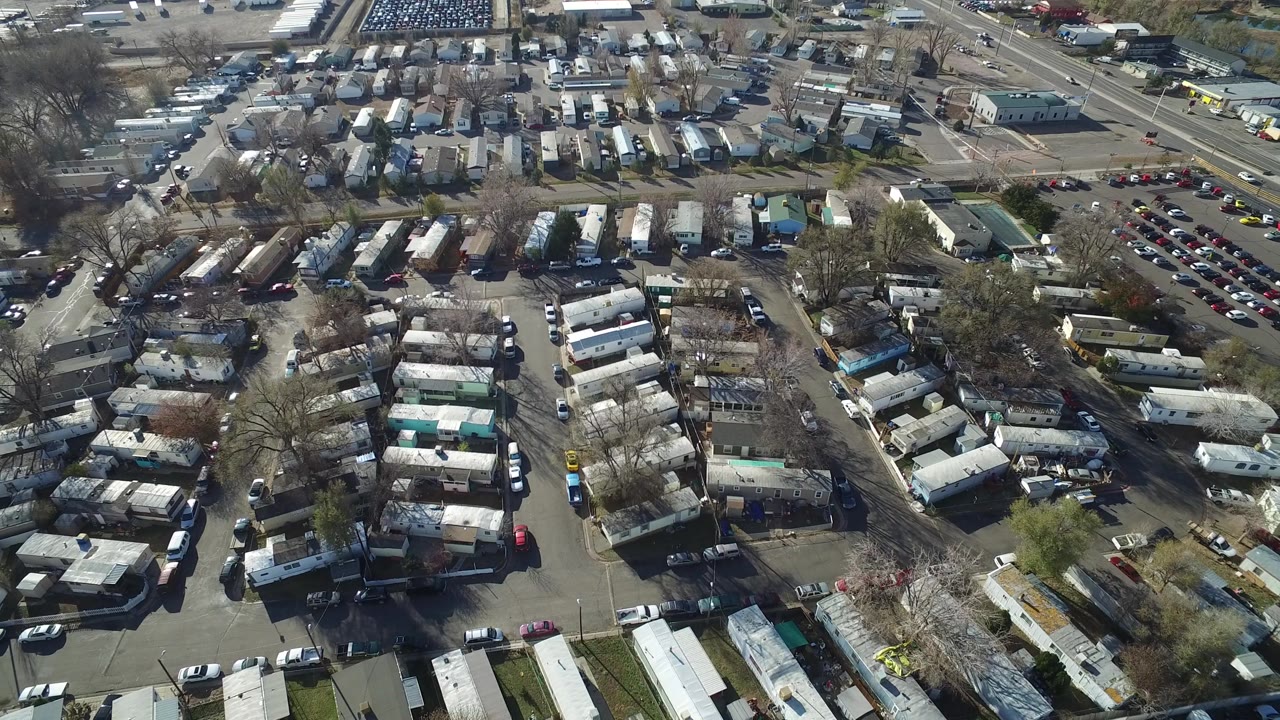 A second aerial frame over Westminster, Colorado centers the trailer rows and parked cars, with a busier road and intersection near the upper edge and no visible people.
