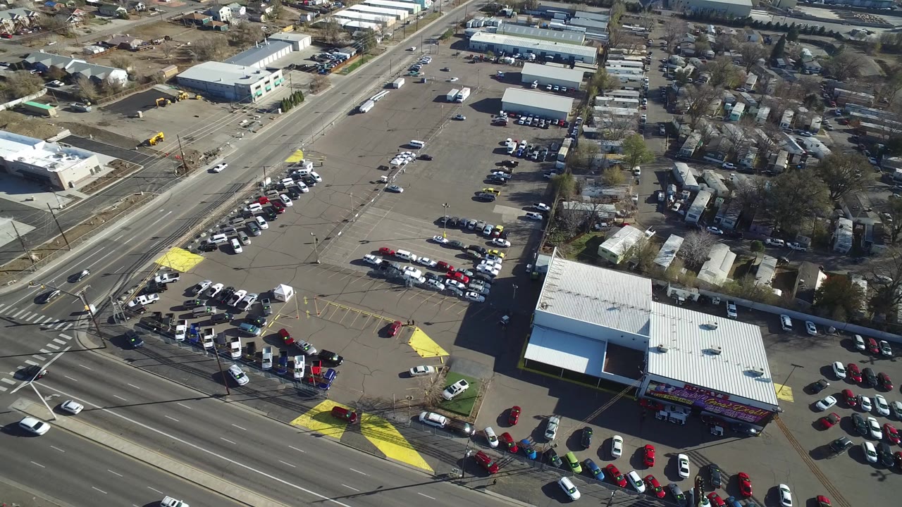 Overhead Westminster, Colorado frame with cars on the main road, a large parking area, commercial rooftops, side streets, and no visible people.
