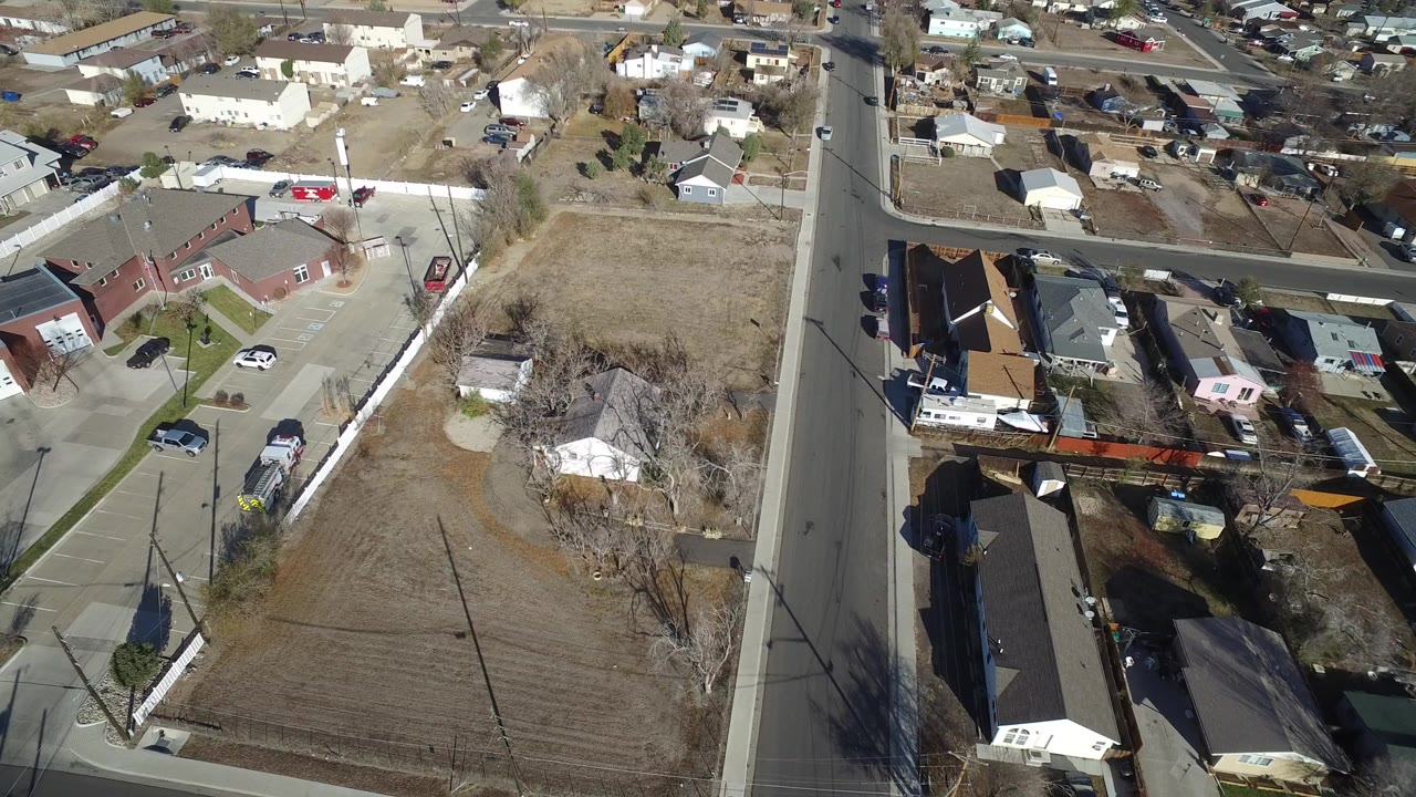 Aerial view of a road beside low buildings and dry lots.