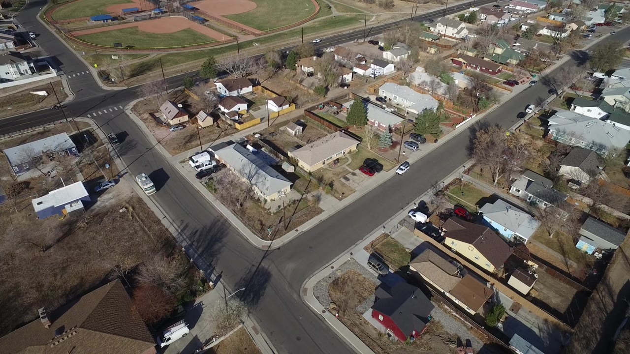 Aerial view of suburban houses near baseball fields and a road intersection.