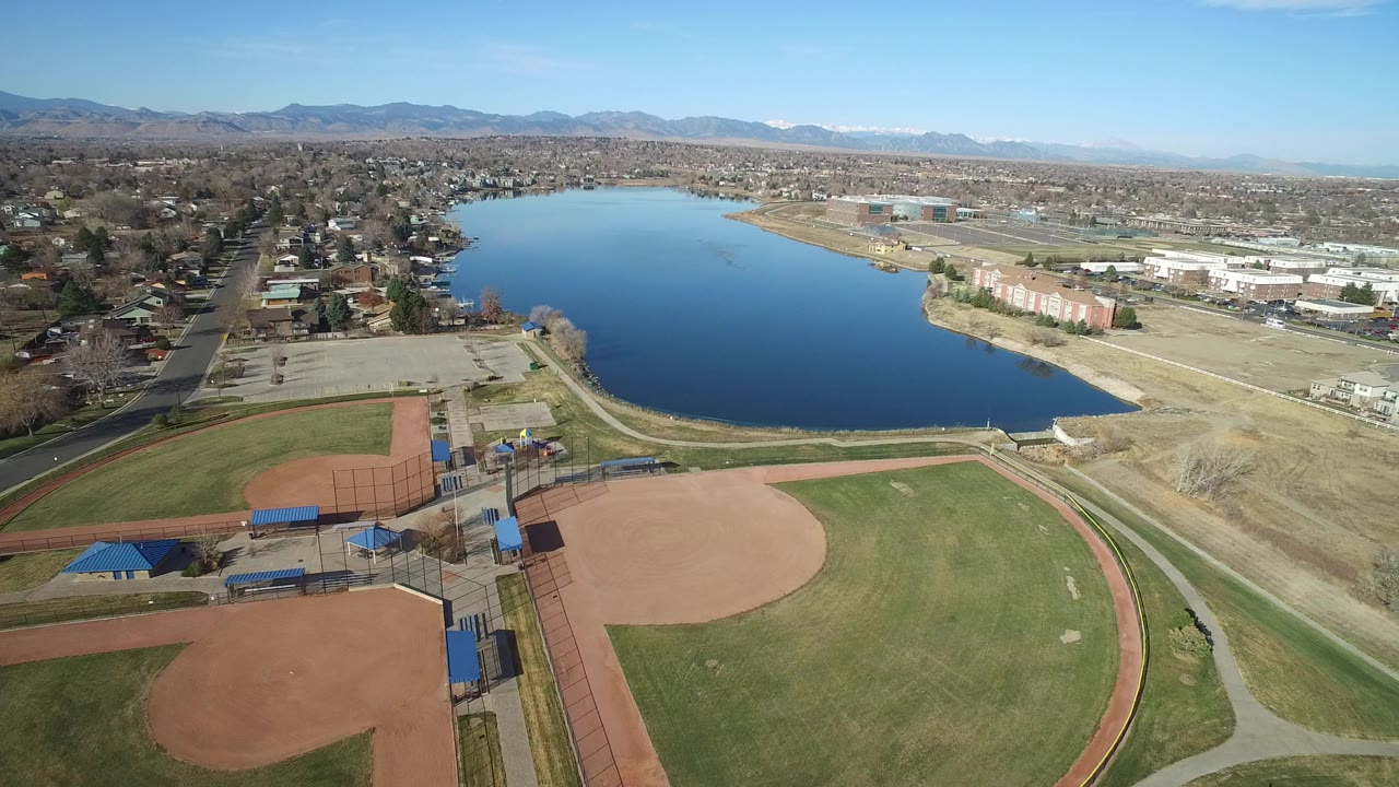 Aerial view of ballfields beside a lake and suburban streets.