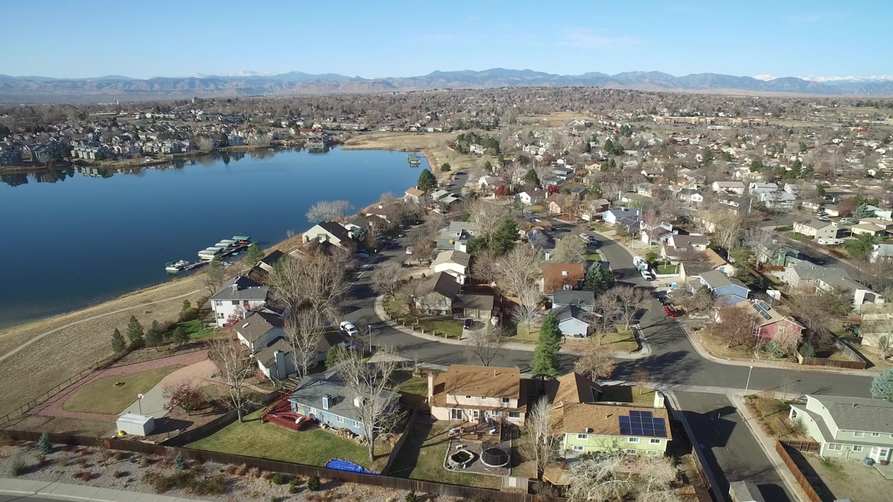 Aerial view of homes beside a lake with mountains in the distance