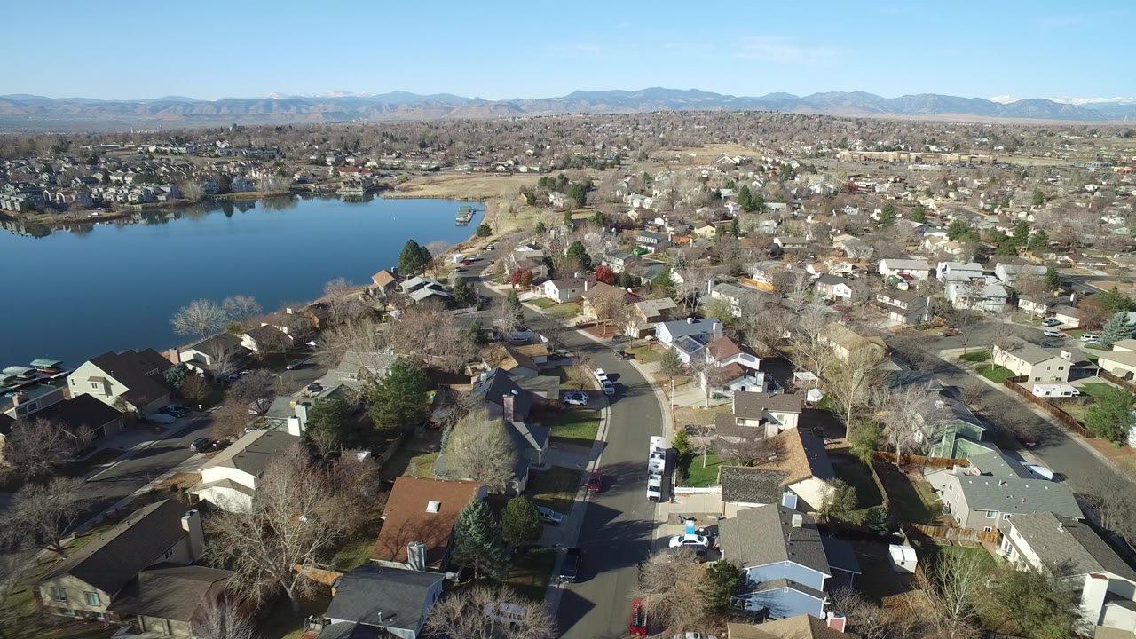Aerial view of suburban homes beside a blue lake.