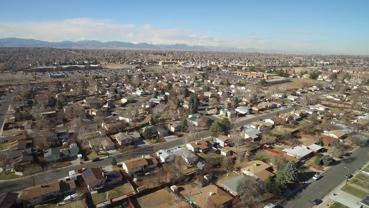 Suburban neighborhood seen from above with road grid and mountains
