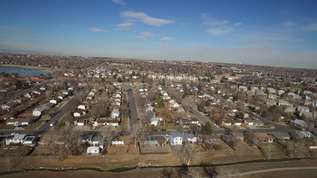 Aerial view over suburban houses and roads near a lake